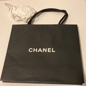 Black Chanel shopping bag with ribbon and Camellia